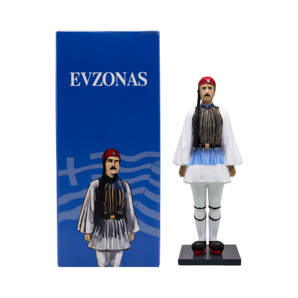 A detailed figurine of an Evzonas soldier, showcasing traditional Greek attire, displayed alongside its packaging featuring the word 'EVZONAS' and a Greek flag design.
